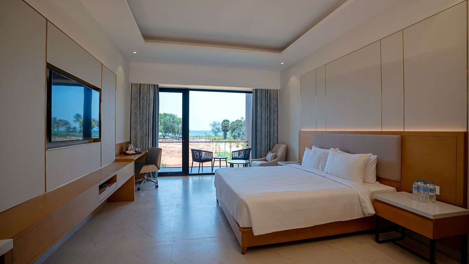 A spacious room of the Bay View Bliss at The Shore, Trishvam with ample of natural light coming from the french windows.