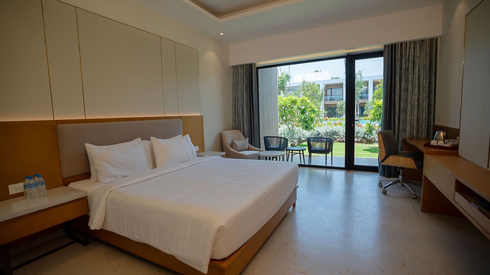 The Garden Courtyard room with huge french windows in the corner of the room at The Shore, Trishvam.