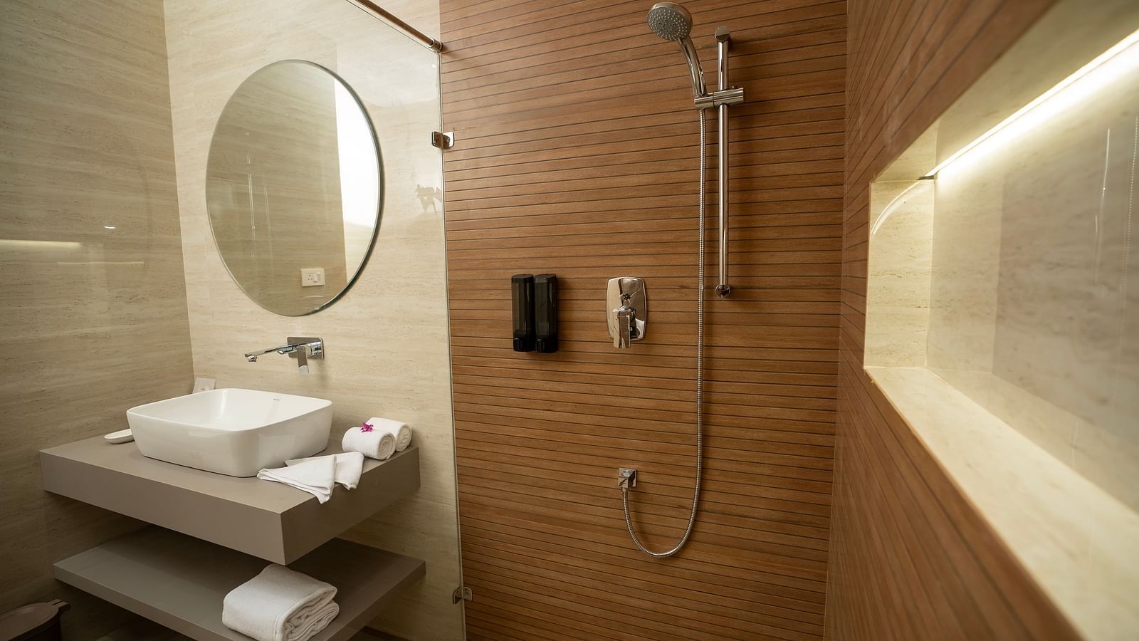 The bathroom of the Exotic Pool Villa with the shower area separated by a glass partition at The Shore, Trishvam.