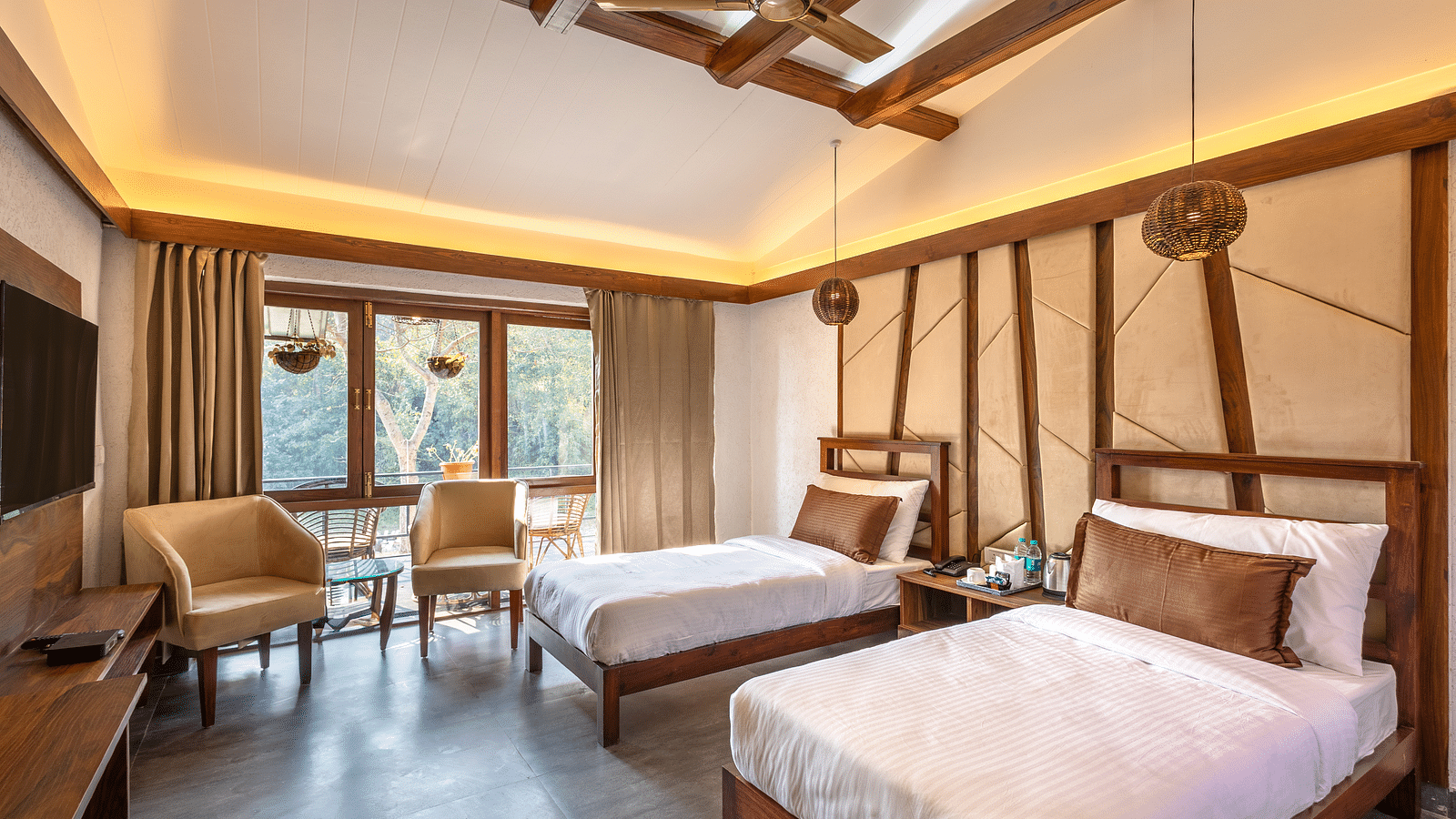Twin beds facing the TV of River View Room at the Sylvan Retreat, Dehradun. 