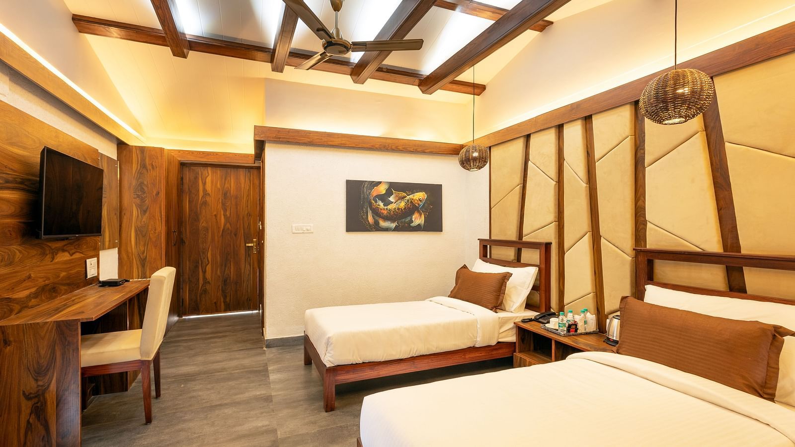 Twin beds facing the TV of River View Room at the Sylvan Retreat, Dehradun. 
