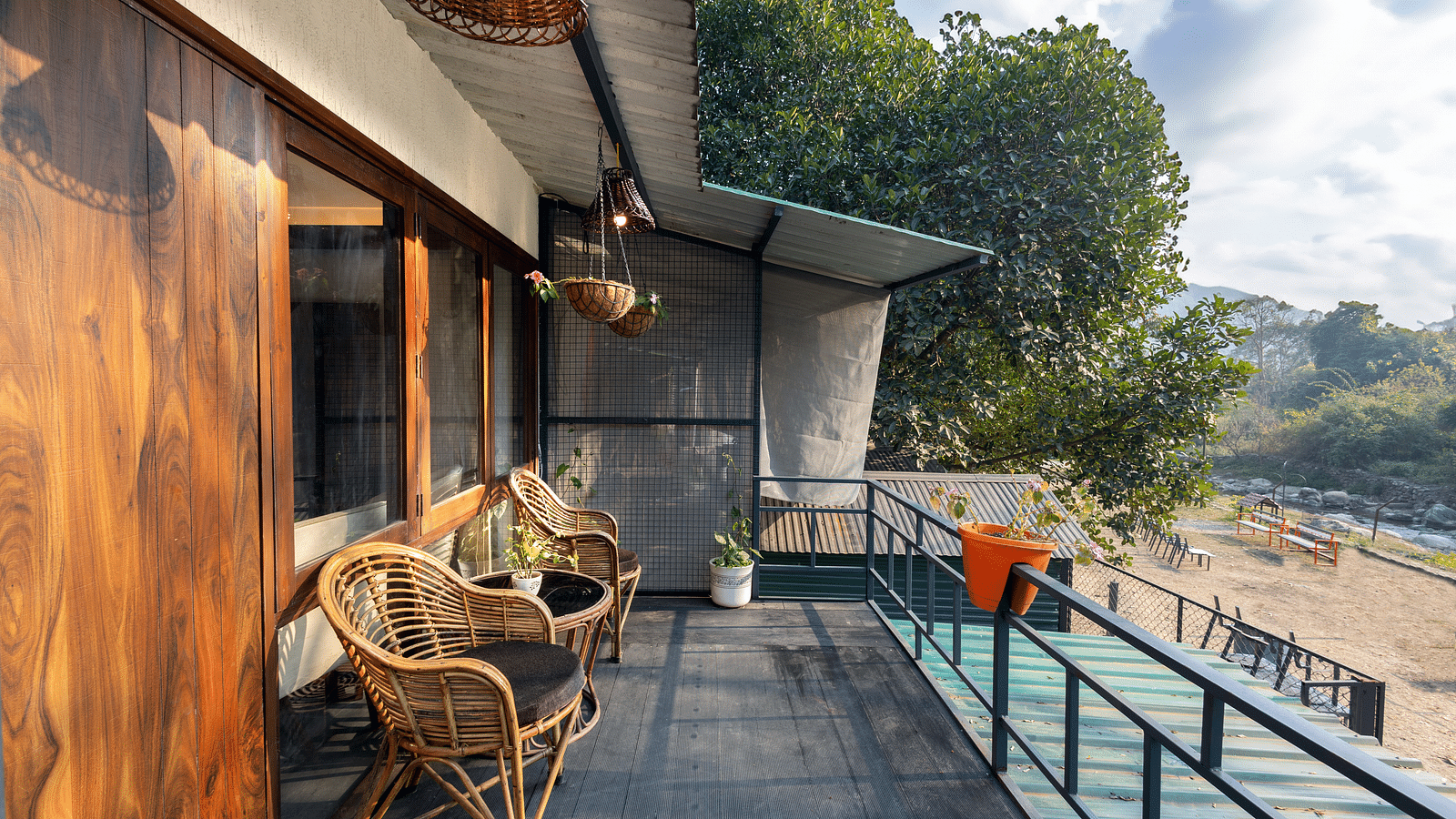 The balcony with chairs facing the view of River View Room at the Sylvan Retreat, Dehradun.