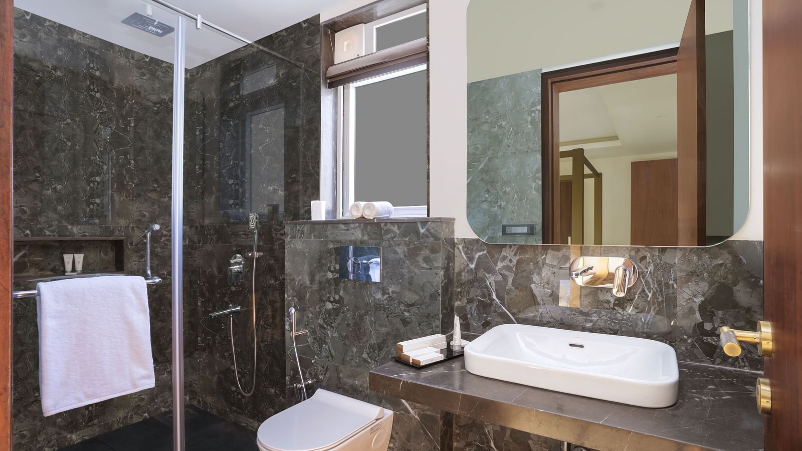 An overview of a bathroom with sink area in view in one of the rooms - The Tanisi Hotels & Resorts, Goa