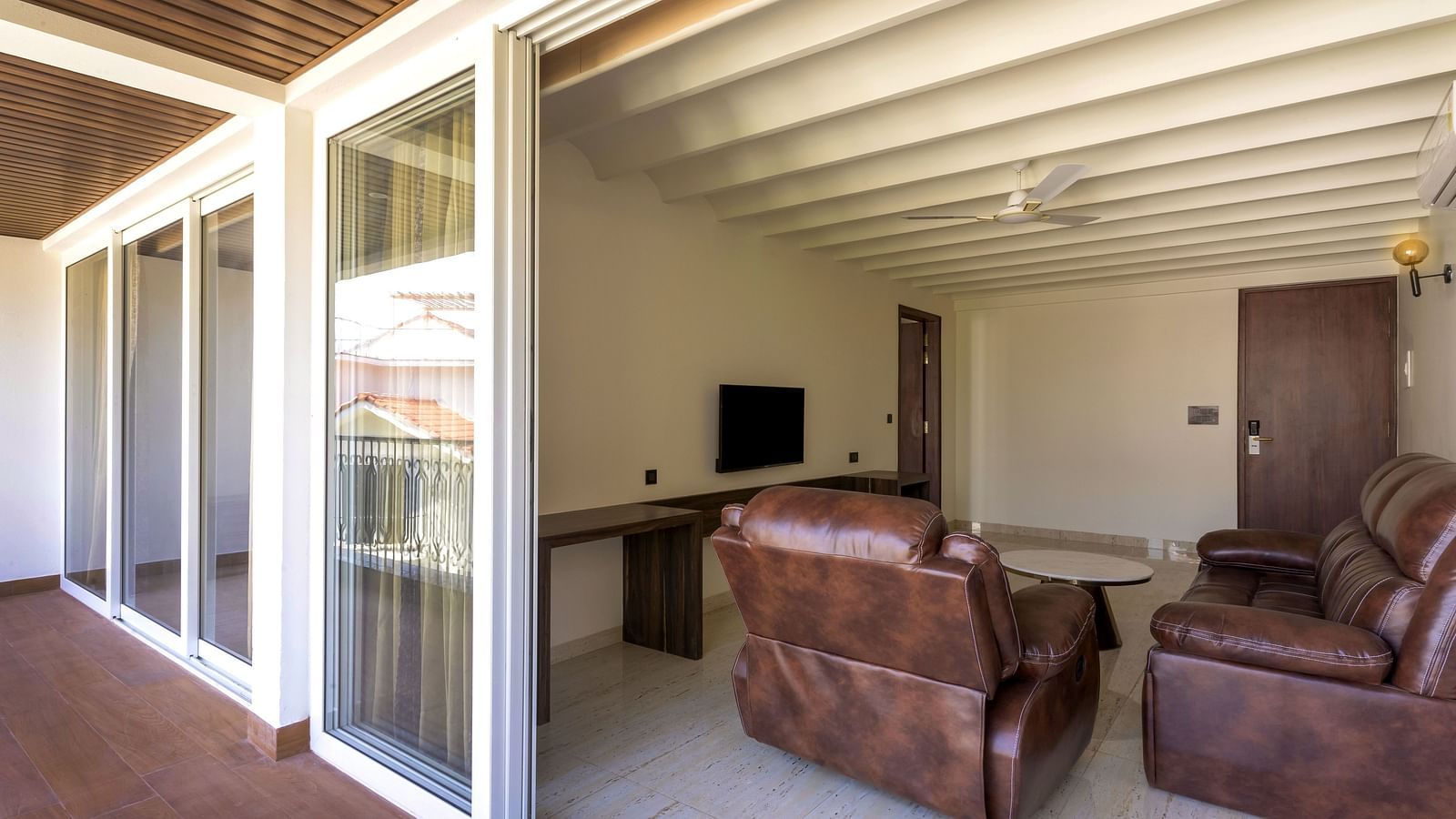 Overview of the living room with sofas and tv in view - The Tanisi Hotels & Resorts, Goa