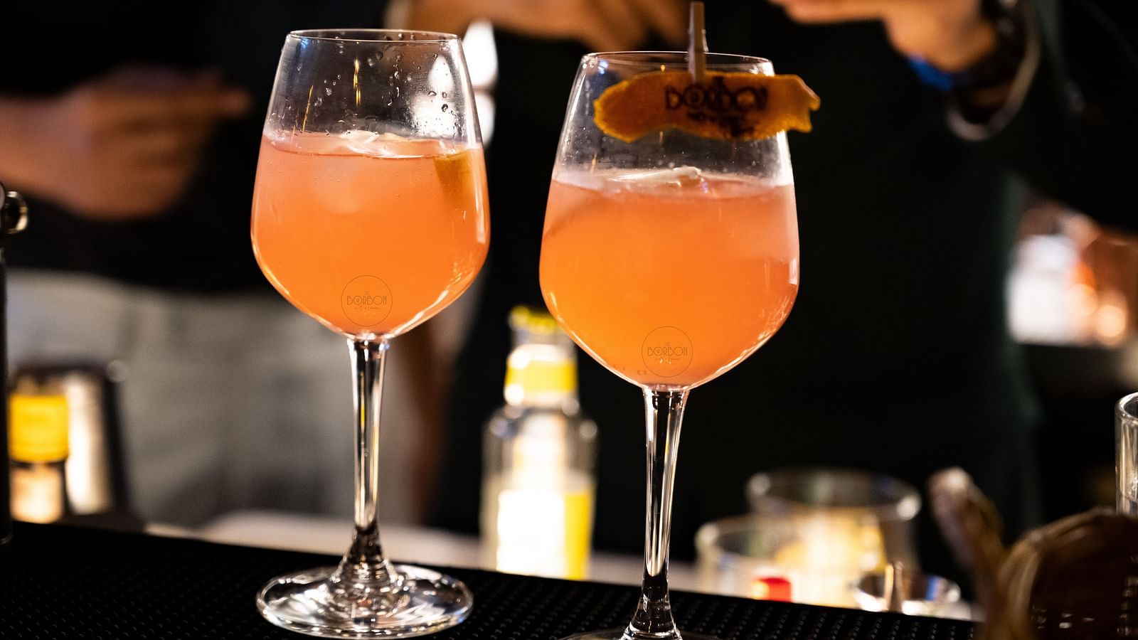 image of two wine glasses with orange coloured beverage at the bourbon club and lounge - The Tattva Boutique Resort