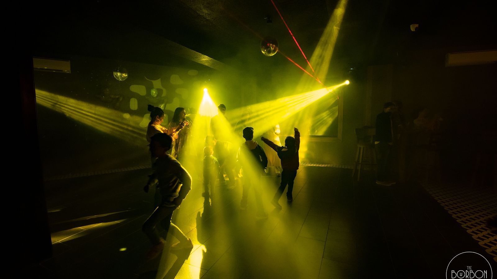 image of people dancing on the dance floor with yellow beam lights flashing around - The Tattva Boutique Resort