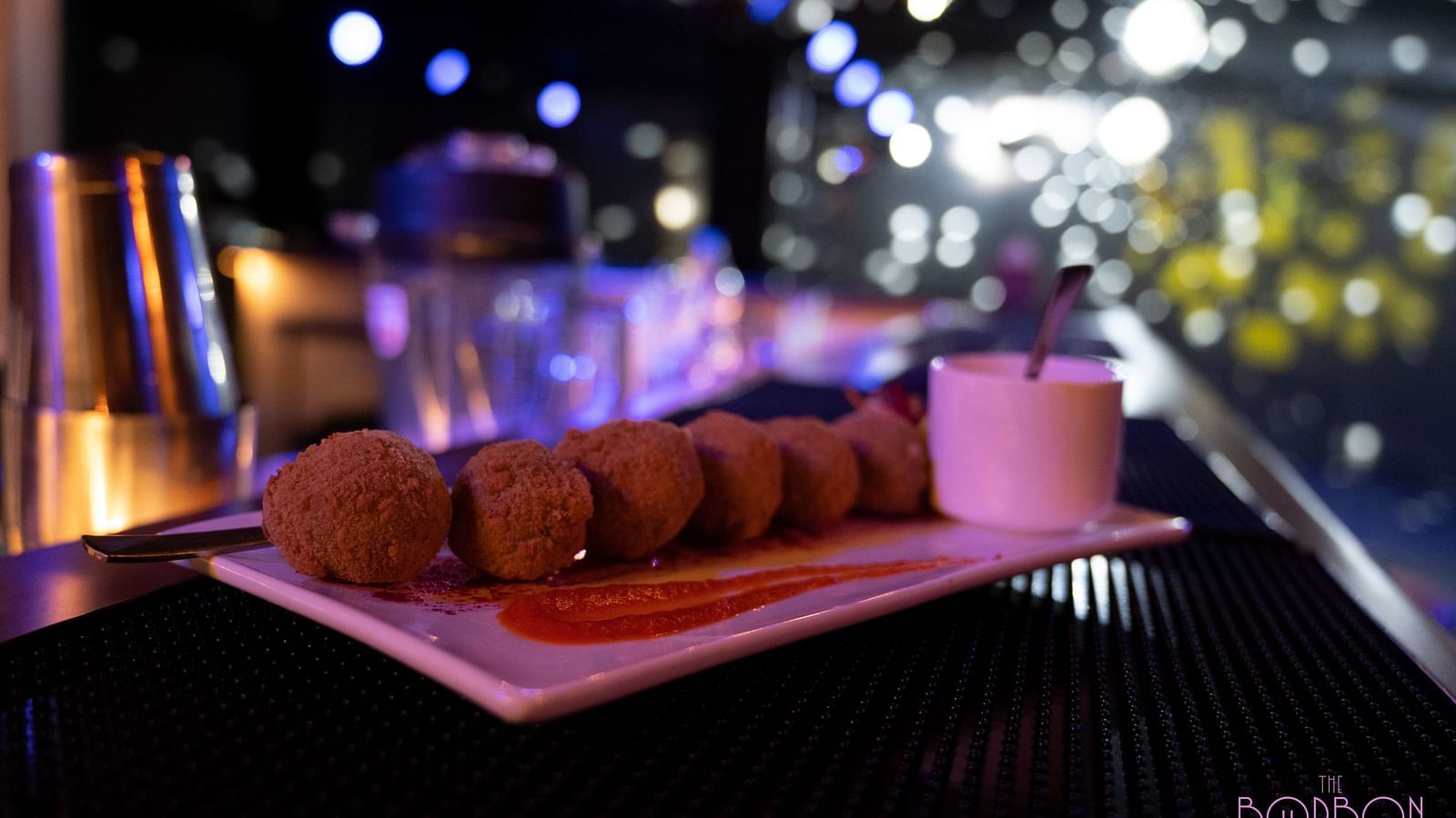 image of a plate with snacks served with a dip at the bourbon club and lounge - The Tattva Boutique Resort