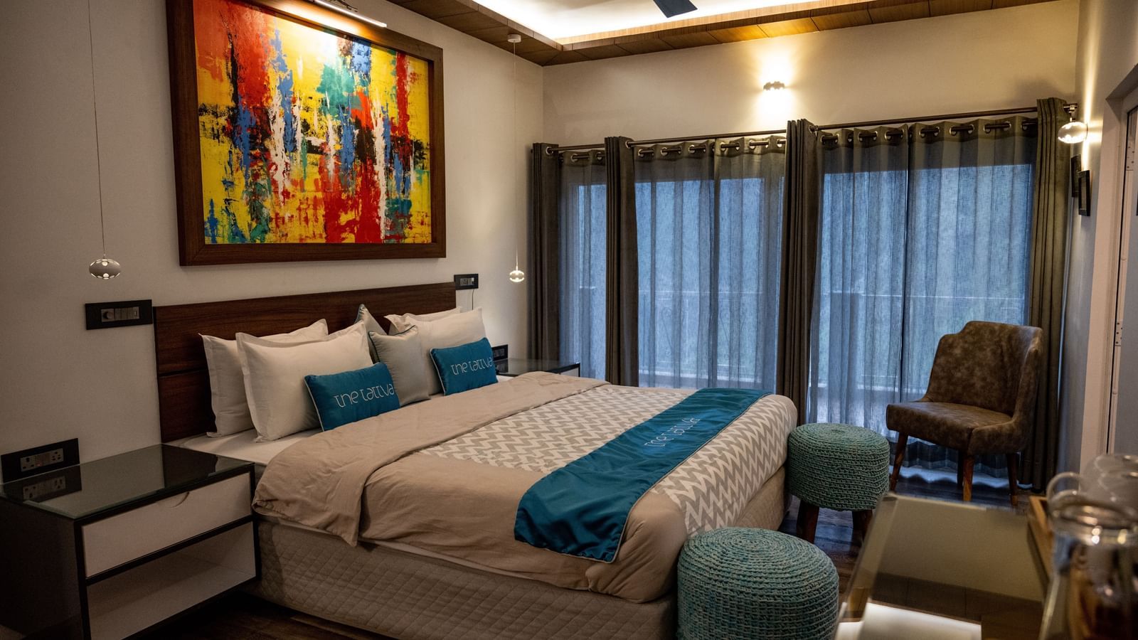 A bedroom at the pent house featuring a beautiful painting hung above the bed - The Tattva Boutique Resort