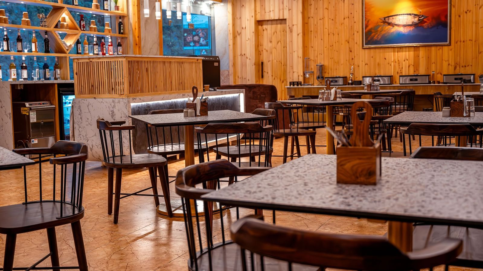Image of the in-house restaurant featuring a fine dining setup, natural  lights and a coffee machine | The Tattva Devprayag