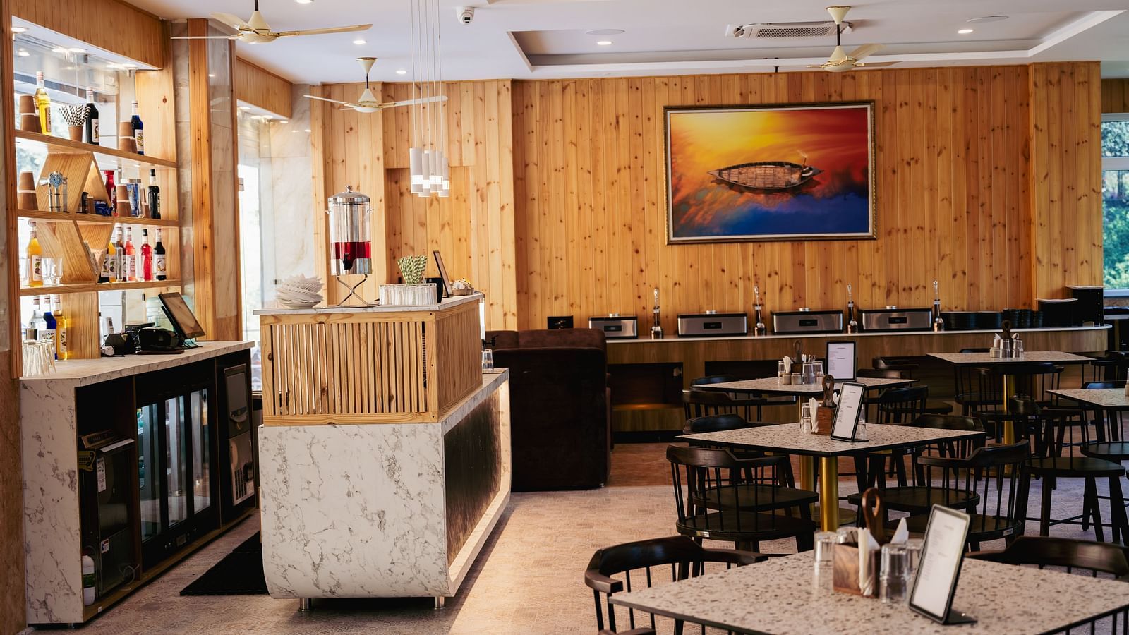 Image of a part of restaurant featuring the bar section and some vacant tables | The Tattva Devprayag