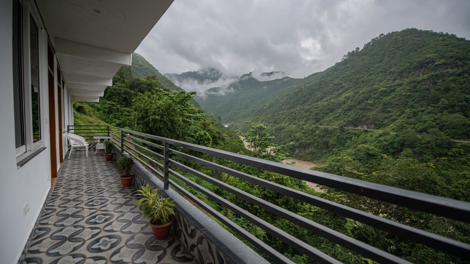 A balcony of the standard room at The Tattva Devaprayag with a view of the mountains and the river.