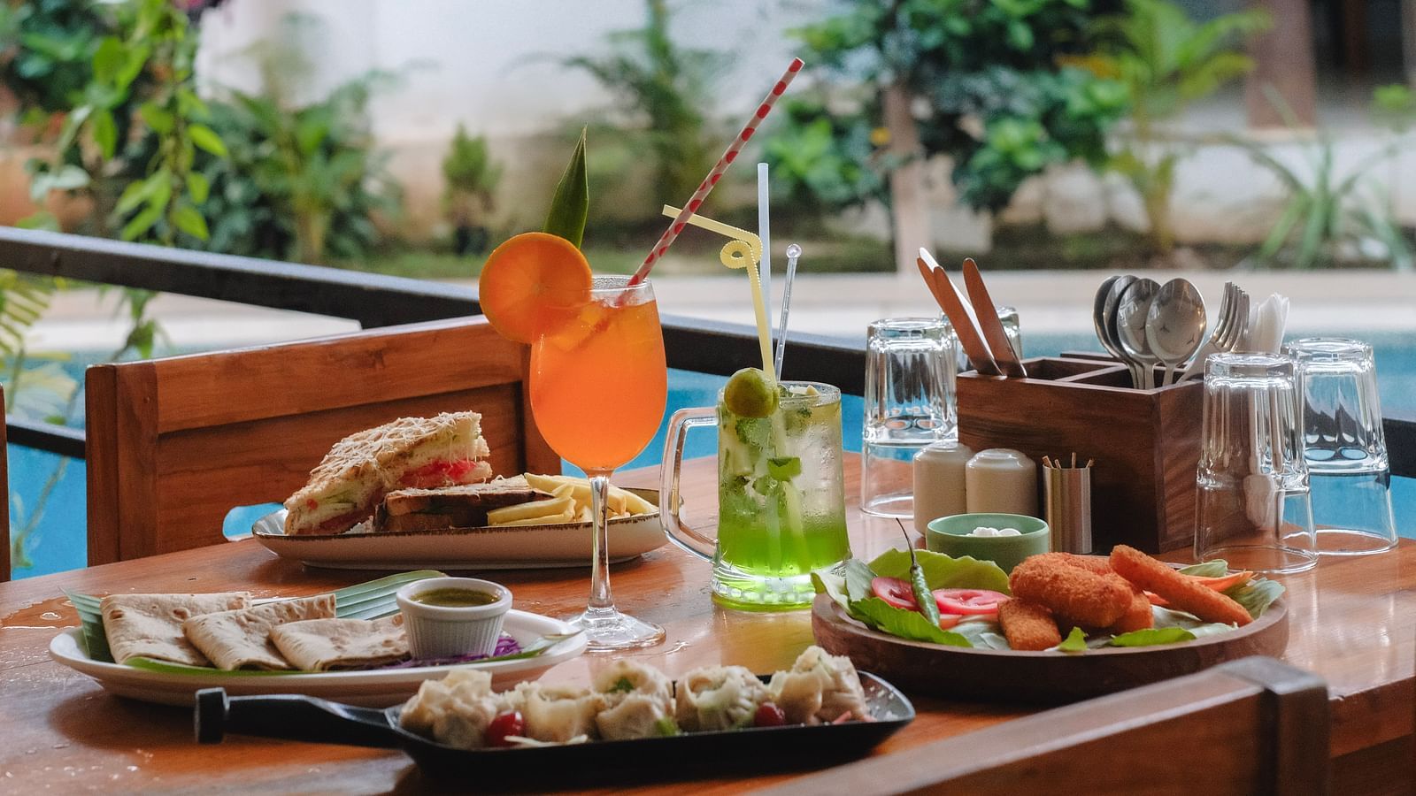 A tropical-style breakfast spread with fresh juice, salads, and continental dishes on a patio table – The Verda de Miranda Resort.