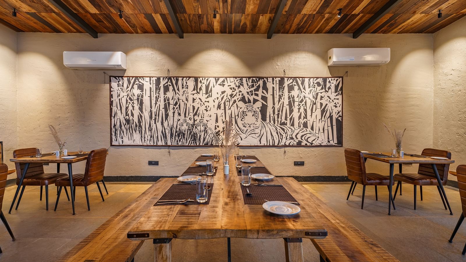 The dining area with wooden benches and tables and chair for seating at Trees N Tigers, Tadoba.