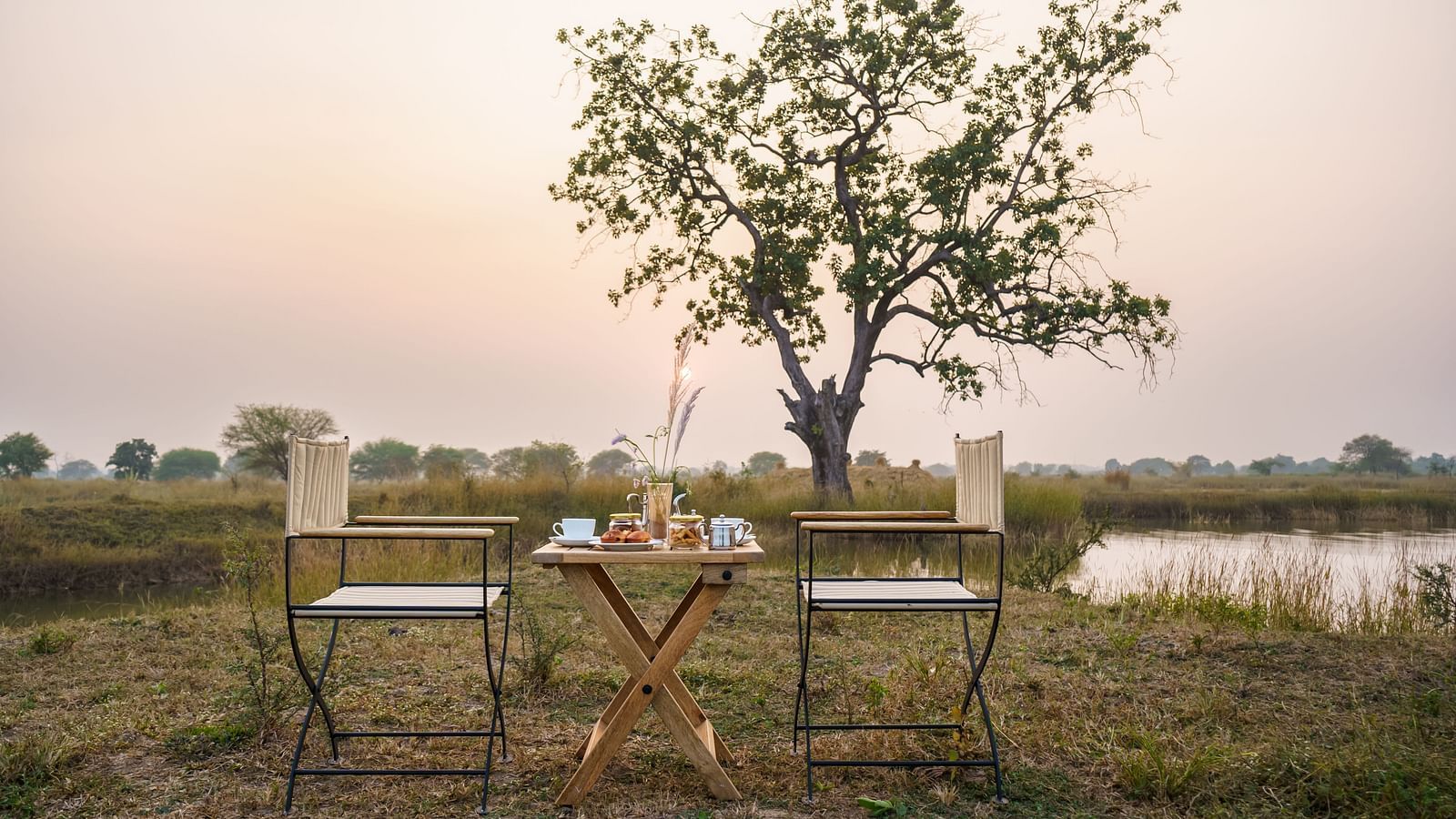 An open space with two chairs and a table at Trees N Tigers, Tadoba.