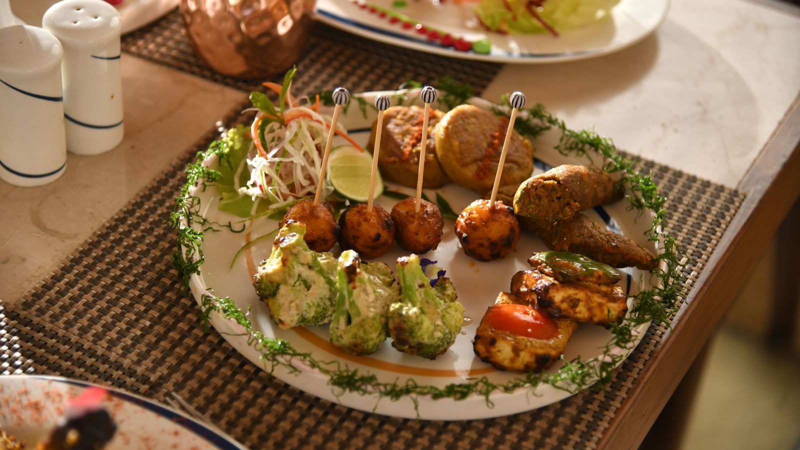 A plate of assorted food on a table at Vedic Village Spa Resort | Yagna