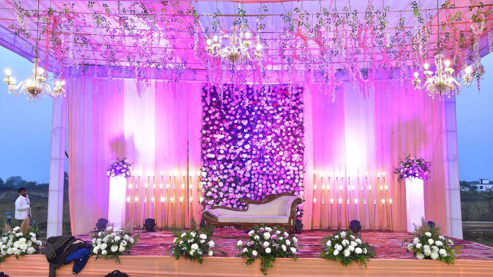 Grand wedding stage with pink floral backdrop at Vedikant Hotels & Resorts.