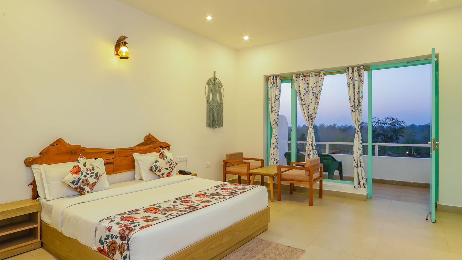 A cosy bedroom at Vedikant Resorts The Mallard Corbett includes a bed, chairs, and a view through the balcony.