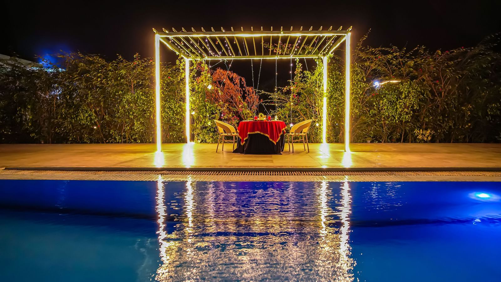 Another view of the illuminated gazebo by the pool at Vedikant Resorts The Mallard Corbett shows reflections in the water at night.