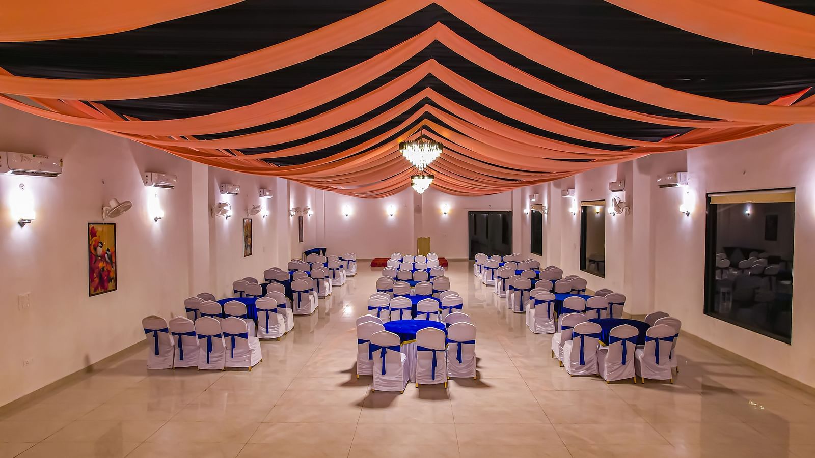 An indoor dining area at Vedikant Resorts The Mallard Corbett features tables and chairs under a decorated ceiling with lighting.