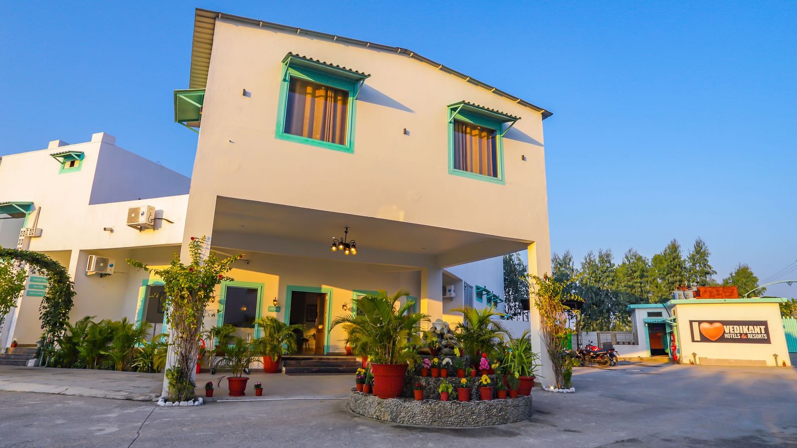 An exterior view of Vedikant Resorts The Mallard Corbett shows the building's facade against a clear blue sky.
