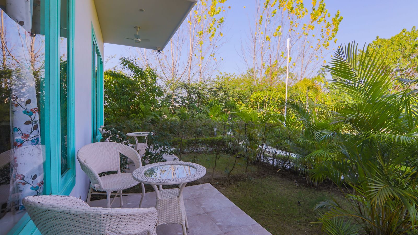 Outdoor seating area with round table and chairs outside the room at Vedikant Resorts The Mallard Corbett, overlooking the garden.
