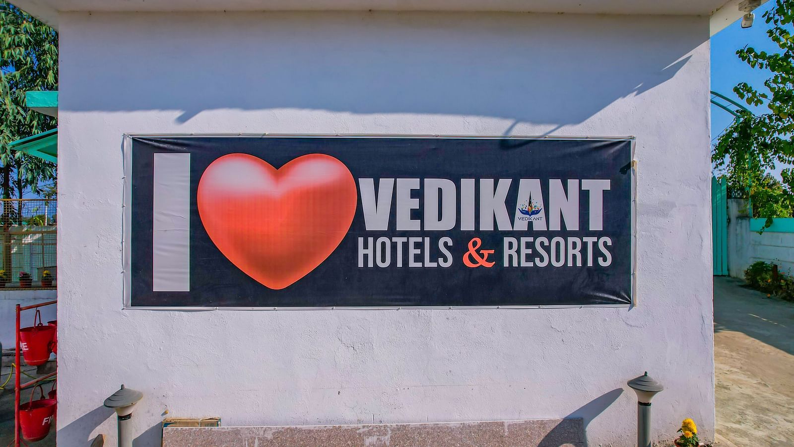 A large wall at Vedikant Resorts The Mallard Corbett featuring the 'I Love Vedikant Hotels & Resorts' signage with a paved area in front.