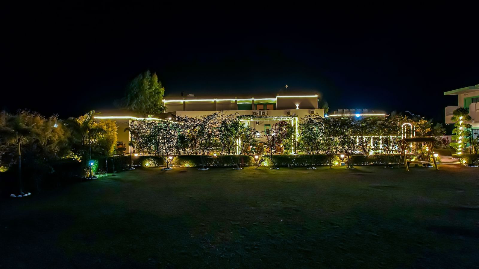 Night aerial view of Vedikant Resorts The Mallard Corbett with building lights, surrounding landscaping, and dark outdoor surroundings.