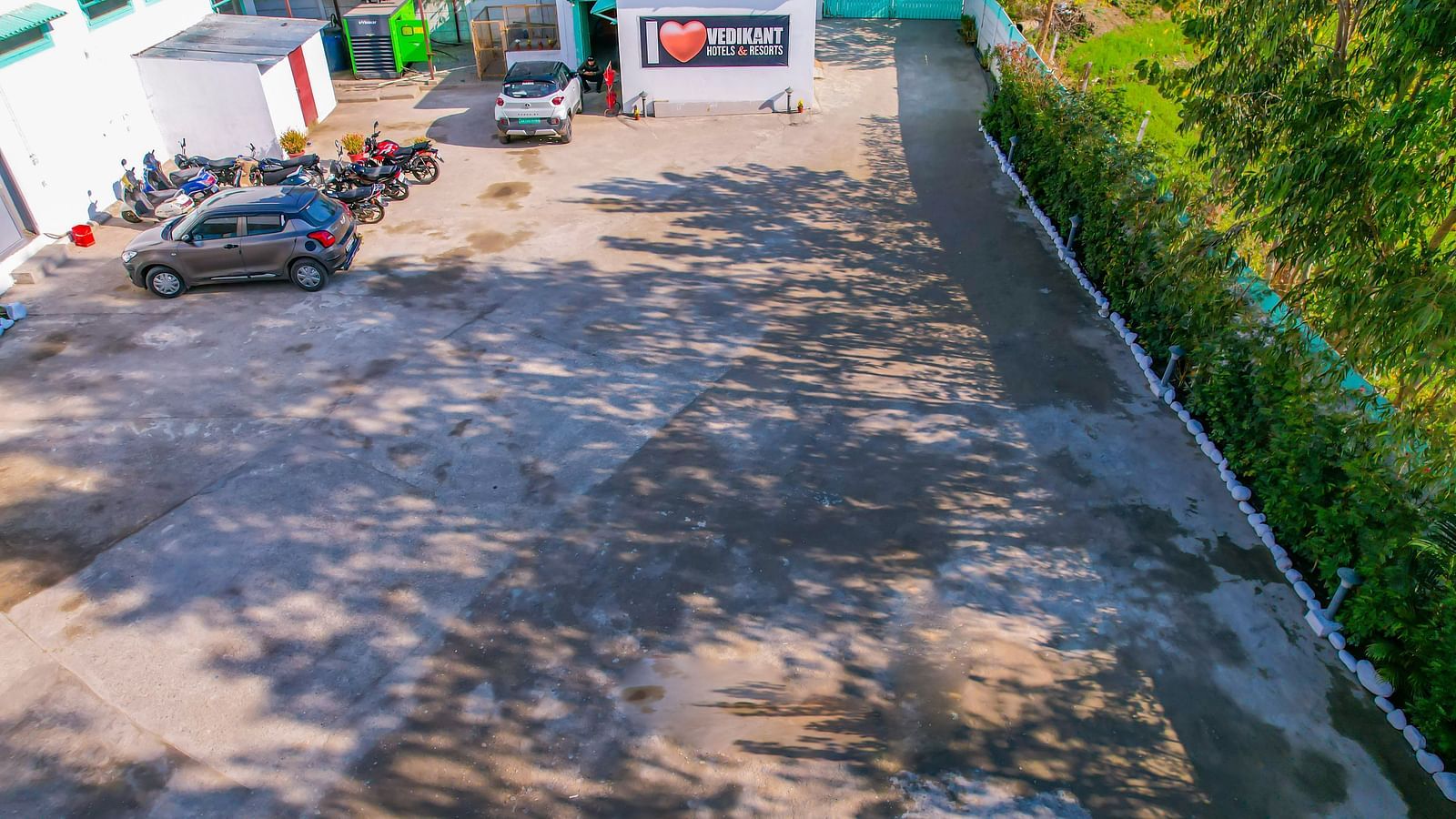 Spacious parking area at Vedikant Resorts The Mallard Corbett with motorbikes and reception block visible.