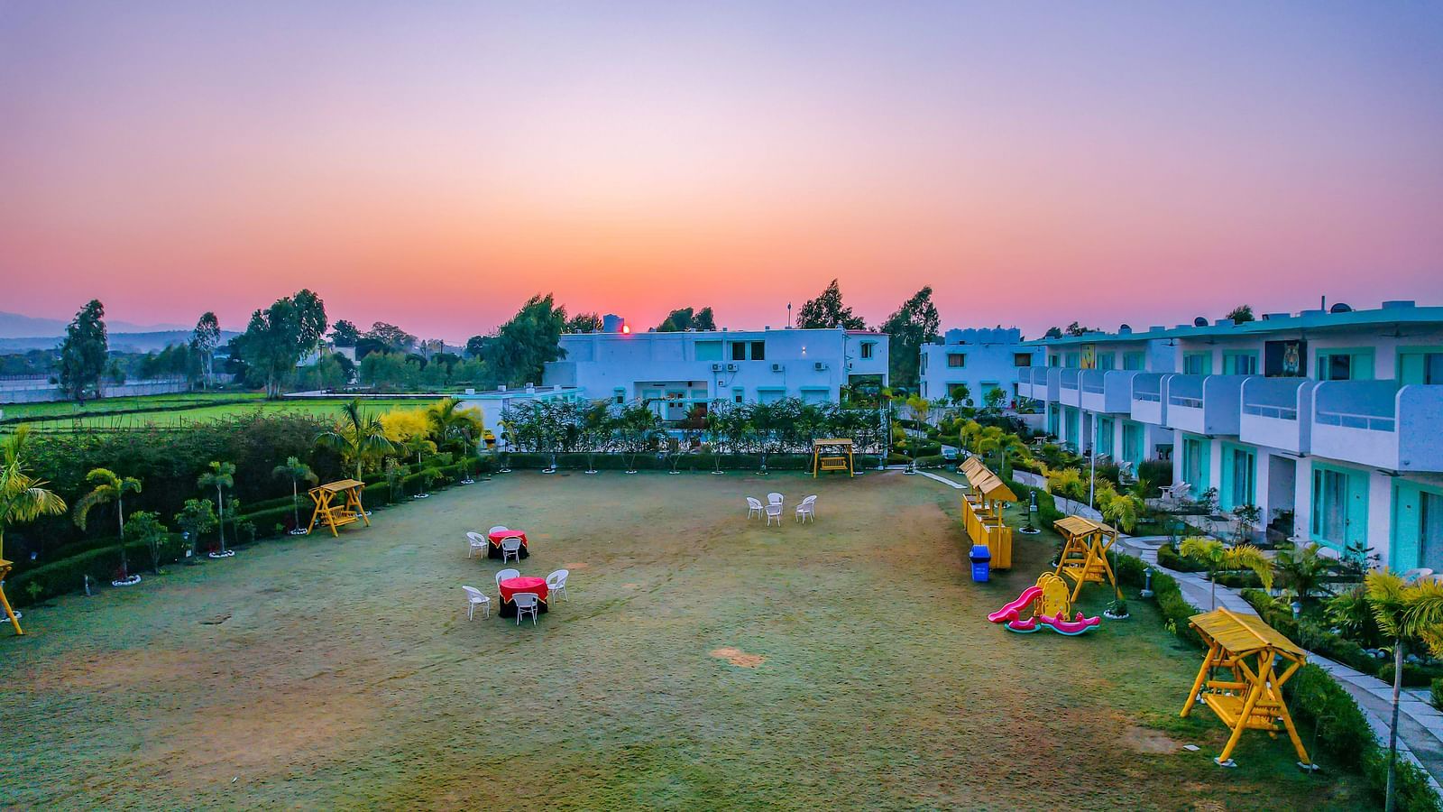 Vibrant garden space at Vedikant Resorts The Mallard Corbett with children's play area and outdoor seating.