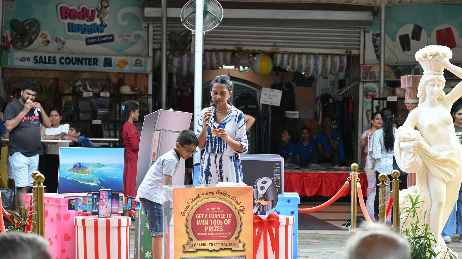 Stage decked with branding as the celebration progresses with attendees watching.