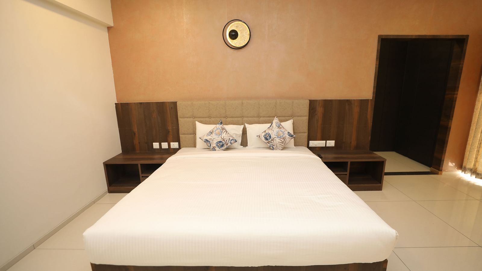 Bed with white sheets and pillows with patterned pillow covers - Welcome Inn Hotels