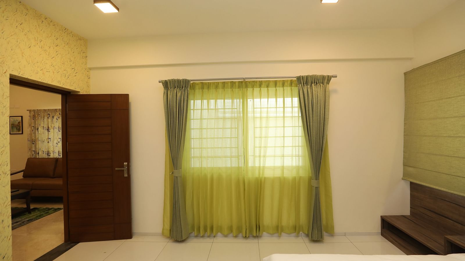 A hotel room with a green curtain covering the window - Welcome Inn Hotels