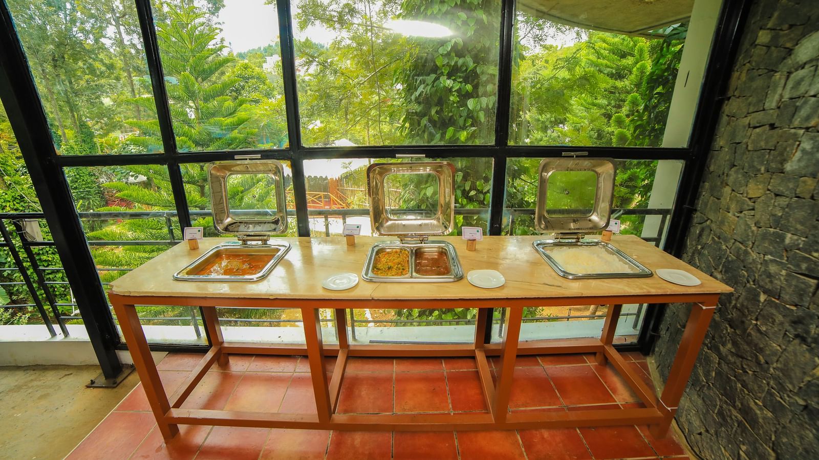Image a buffet table with view of the trees in front at WOW Bison Woods. 