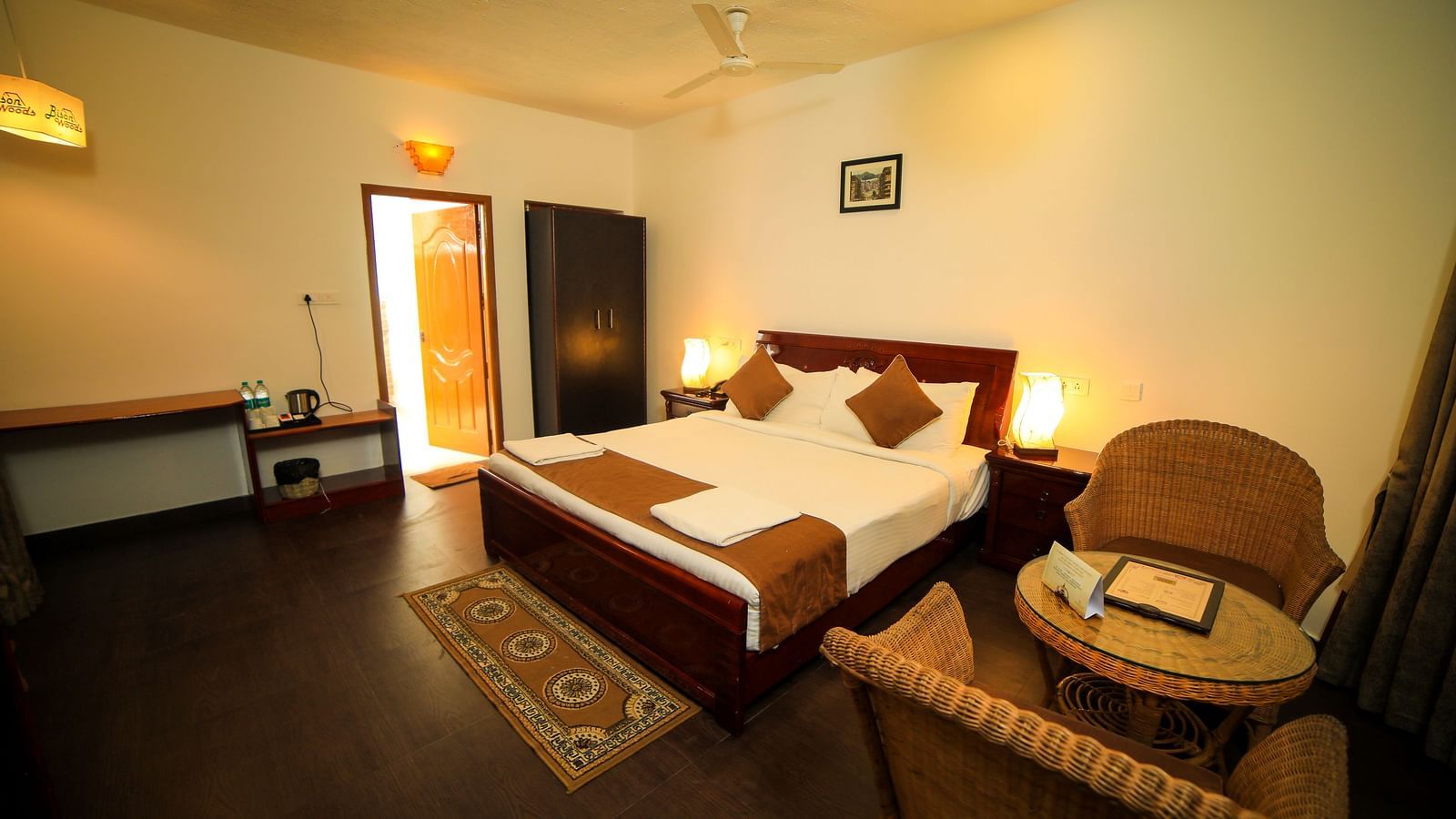 Image of a room with a bed wooden chairs on the side of the bed at WOW Bison Woods.