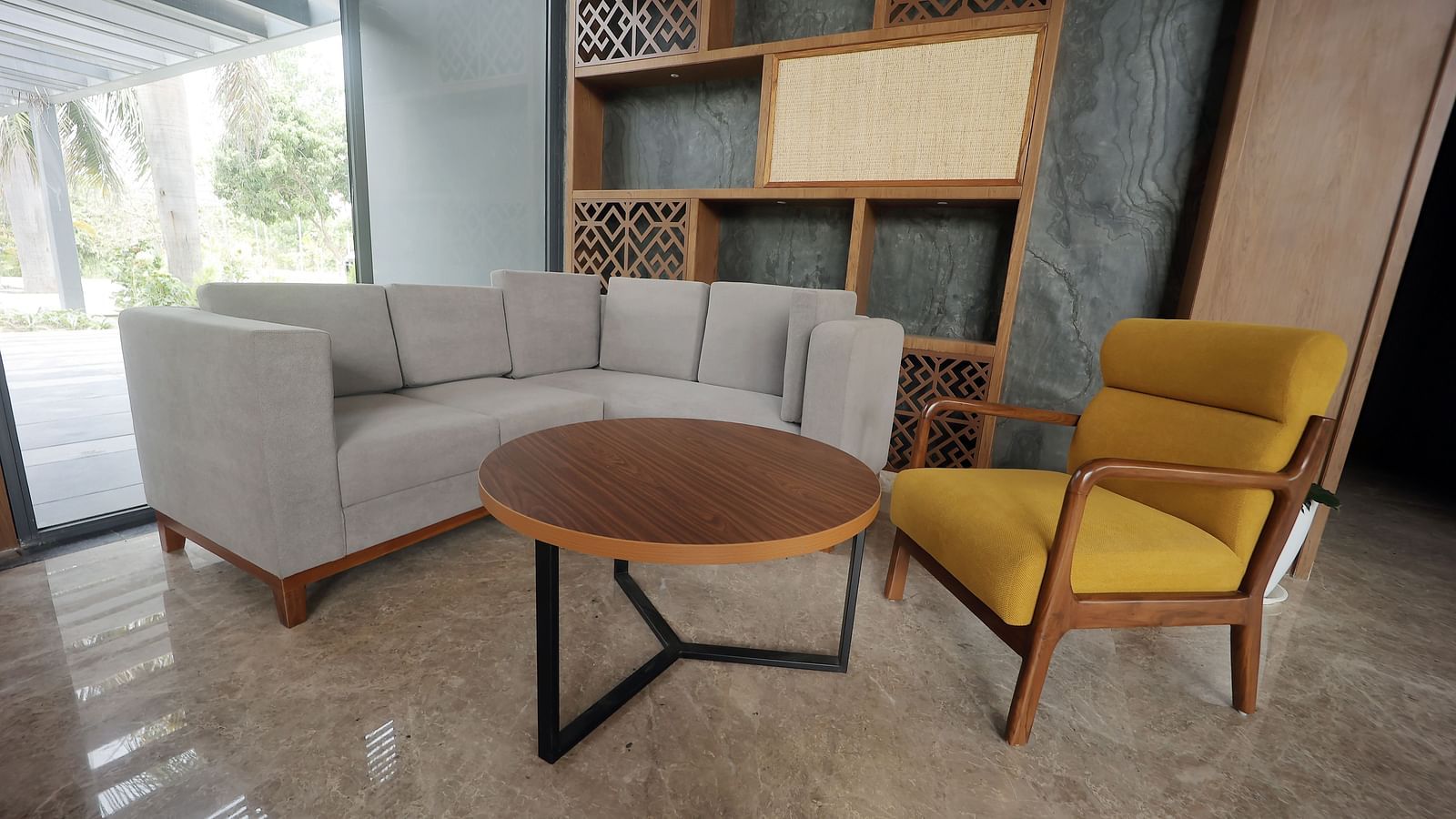 Contemporary seating corner featuring a beige sofa and mustard accent chair beside a decorative shelf at Wyndham Garden.