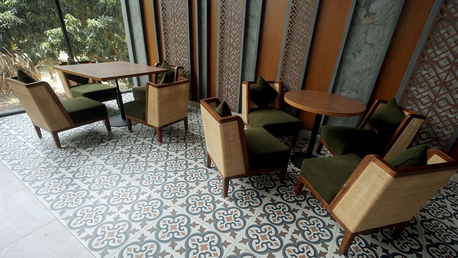 Indoor seating with wooden armchairs and patterned tiled flooring under warm lighting at Wyndham Garden.