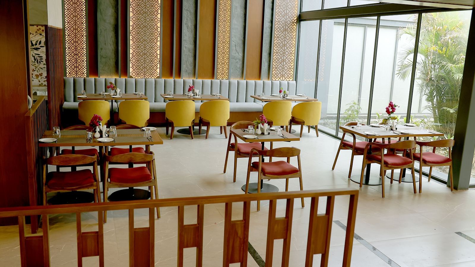 Vibrant indoor restaurant with patterned walls and wooden dining tables at Wyndham Garden.