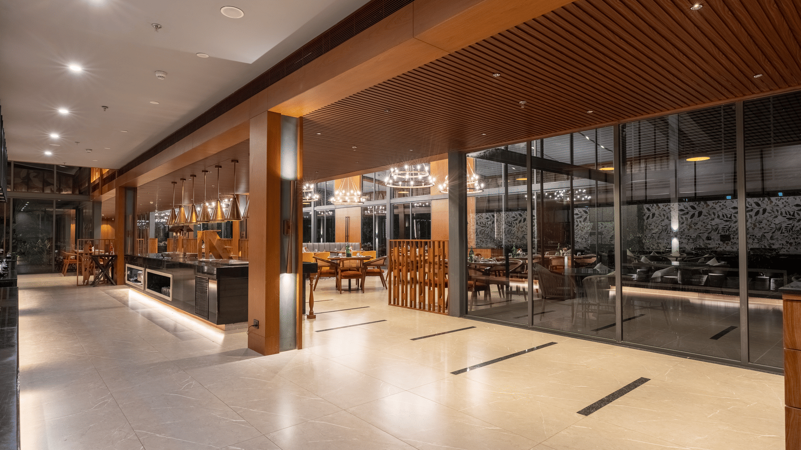 A Wyndham Garden restaurant hallway with glossy floors, wooden ceiling beams, and a view into the main dining space.