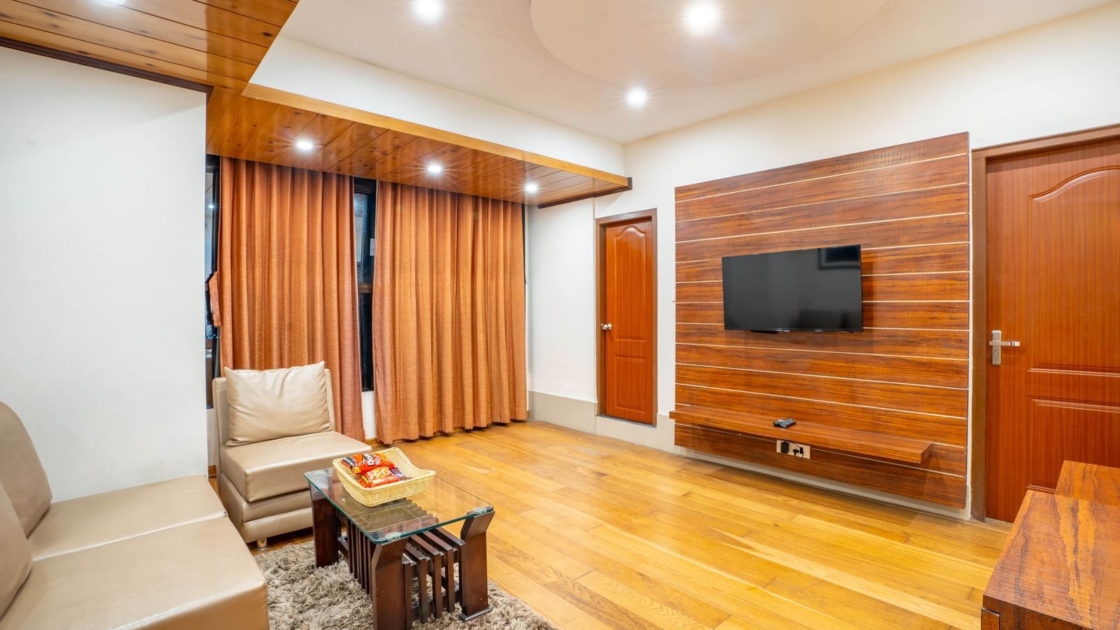 A well-appointed hotel suite with a living area and a flat-screen TV at the Yashshree Jai Hotel & Banquet, Darjeeling.