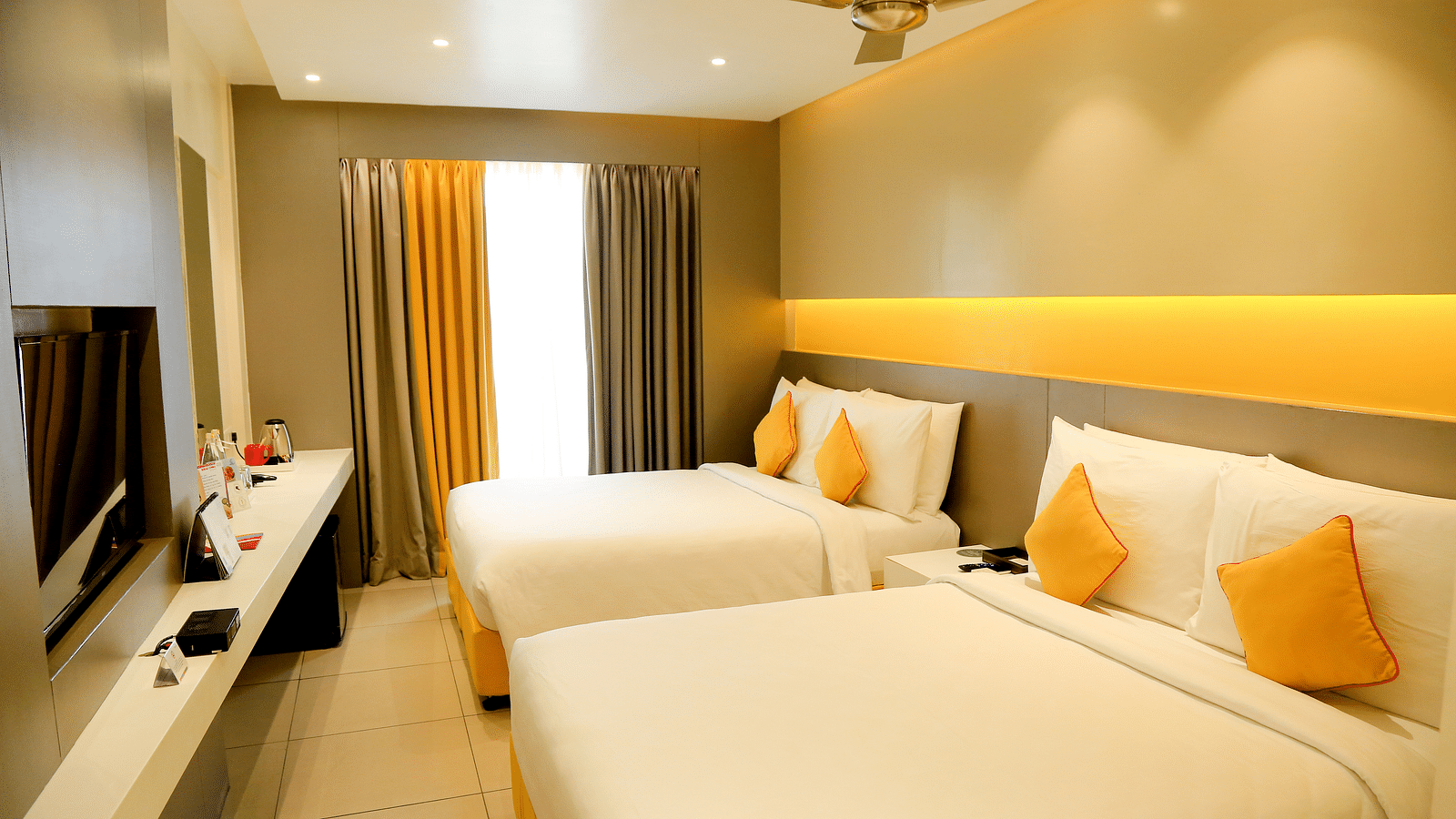 Spacious twin beds with headboards line the wall, large windows with curtains cover them