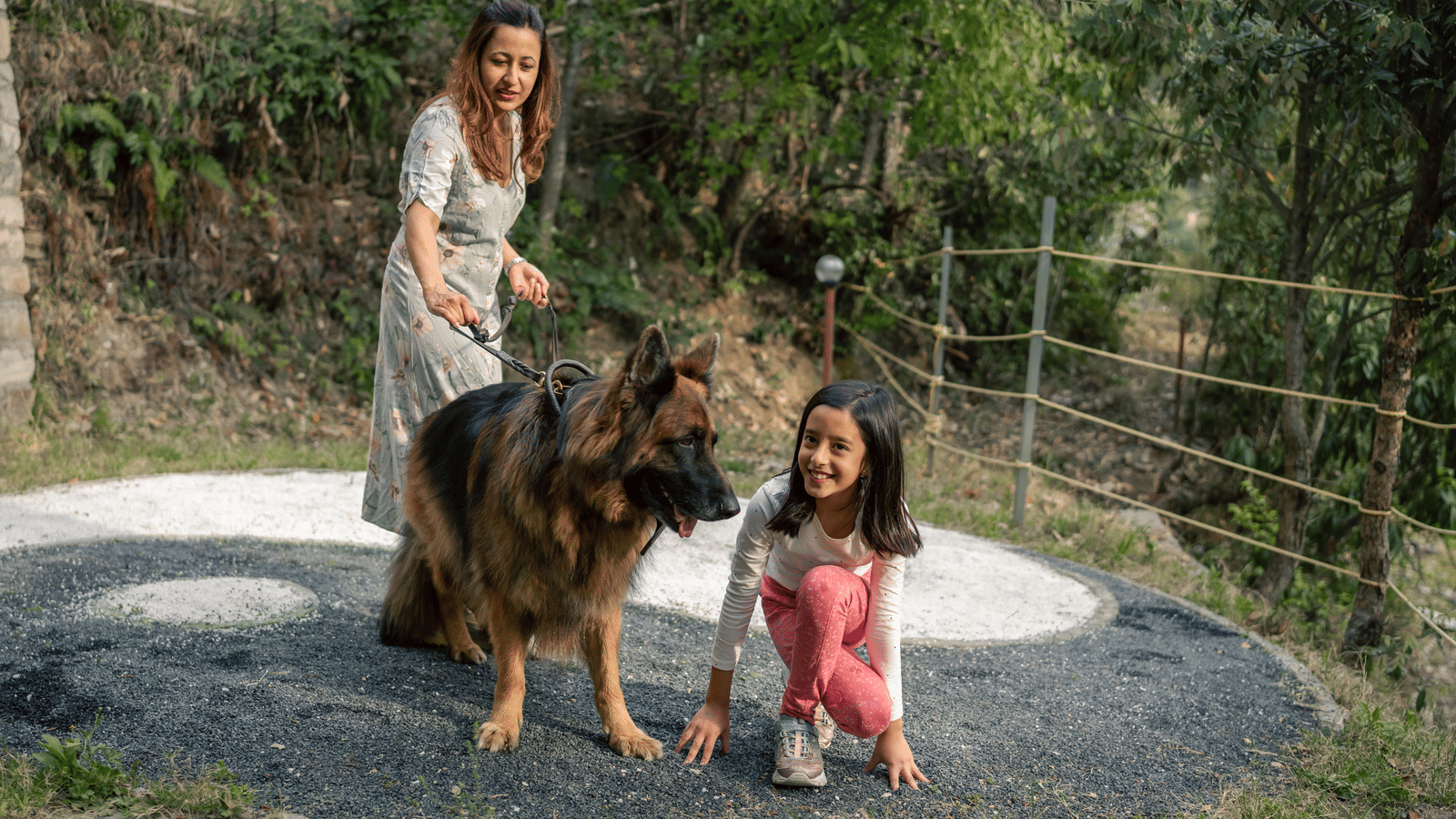 Two girls and a dog are on a path next to a fence at Ziran Retreat.