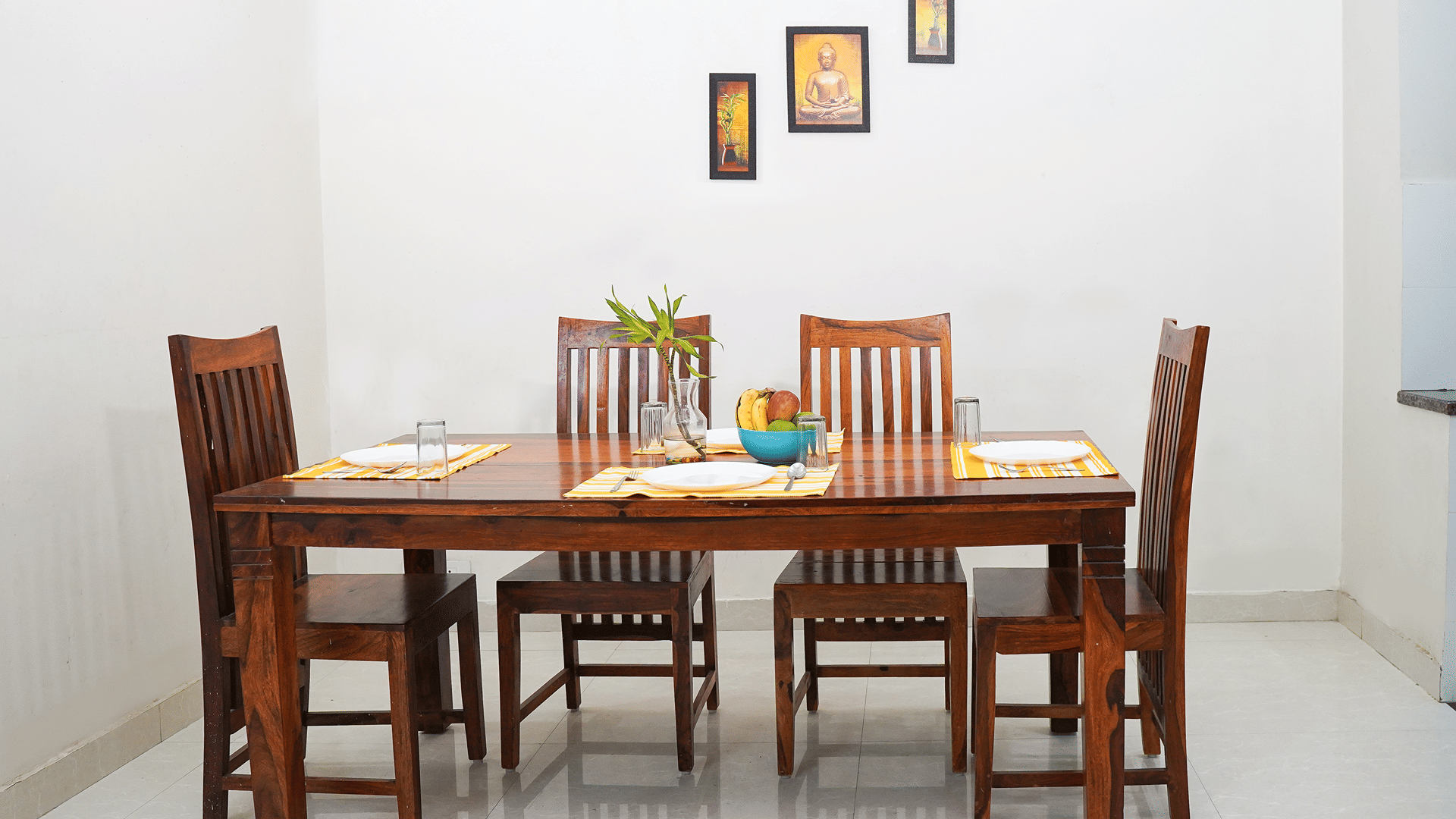 Dining area of Lime Tree Hotels & Service Apartment Private Limited featuring a wooden dining table, chairs, and framed wall decor.