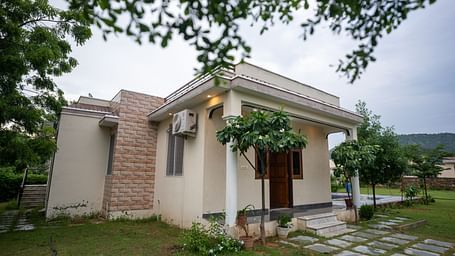 Facade of an accommodation surrounded by plants at Aanandam Resort & Spa, Pushkar.