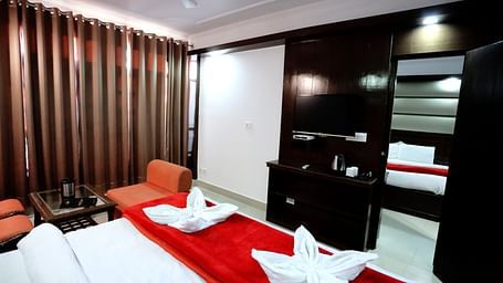 Image of a room with a bed and a door in front of it leading to another room at Amara Hill Queen, Mussoorie.