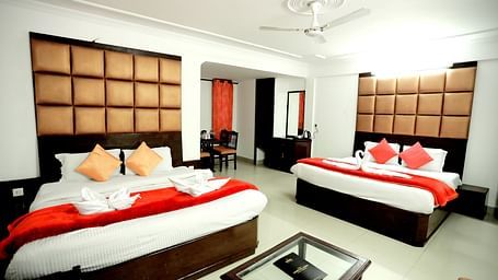 Image of a room with two beds and a table in front of the table at Amara Hill Queen, Mussoorie.