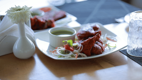 Close up of chicken tikka served with mint chutney along with onion rings at Machaan at Aveda Mountains and Mist Resort and Spa, Munnar.