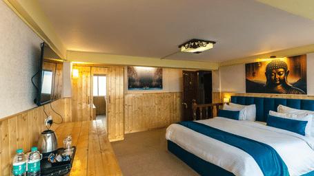 Spacious Premium Room featuring a king size bed and wooden furnishings at Avianna Seven Seas, Darjeeling.