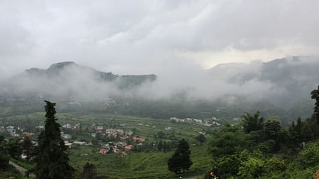 A valley view with a village nestled among hills.
