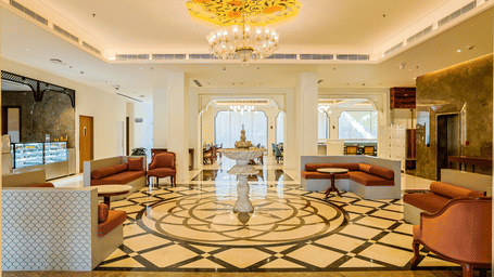 Spacious luxury lobby featuring comfortable seating arrangements, patterned marble flooring, and a central fountain at Bhagirathi by Atishay.