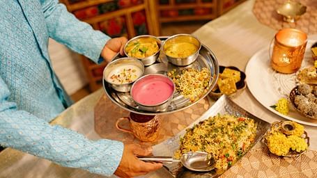 A traditional Indian thali meal, with a variety of vibrant dishes served in metal bowls.